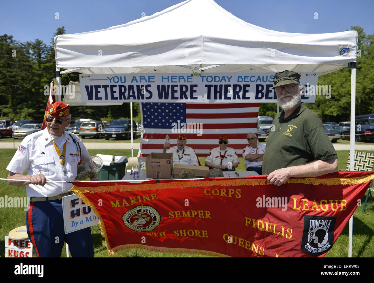 June 7, 2015 - Old Westbury, New York, United States - JOHN GIORDANO of Whitestone, at left, and a fellow marine, hold a red Marine Corps League banner, in front of FREE HUGS By a MARINE fundraising booth of the Marine Corps League North Shore Queens Detachment #240 at the 50th Annual Spring Meet Car Show sponsored by Greater New York Region Antique Automobile Club of America. Over 1,000 antique, classic, and custom cars participated at the popular Long Island vintage car show held at historic Old Westbury Gardens. (Credit Image: © Ann Parry/ZUMA Wire) Stock Photo