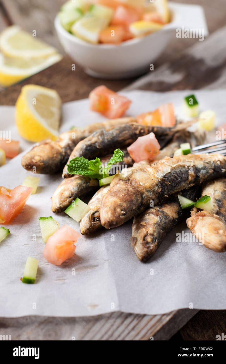 deep fried sardines with lemon and salad on white paper Stock Photo Alamy