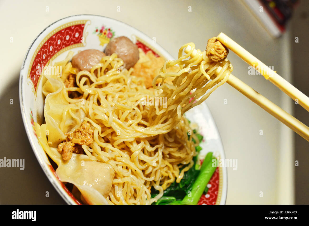 Chopsticks picking up noodles and meat Stock Photo Alamy