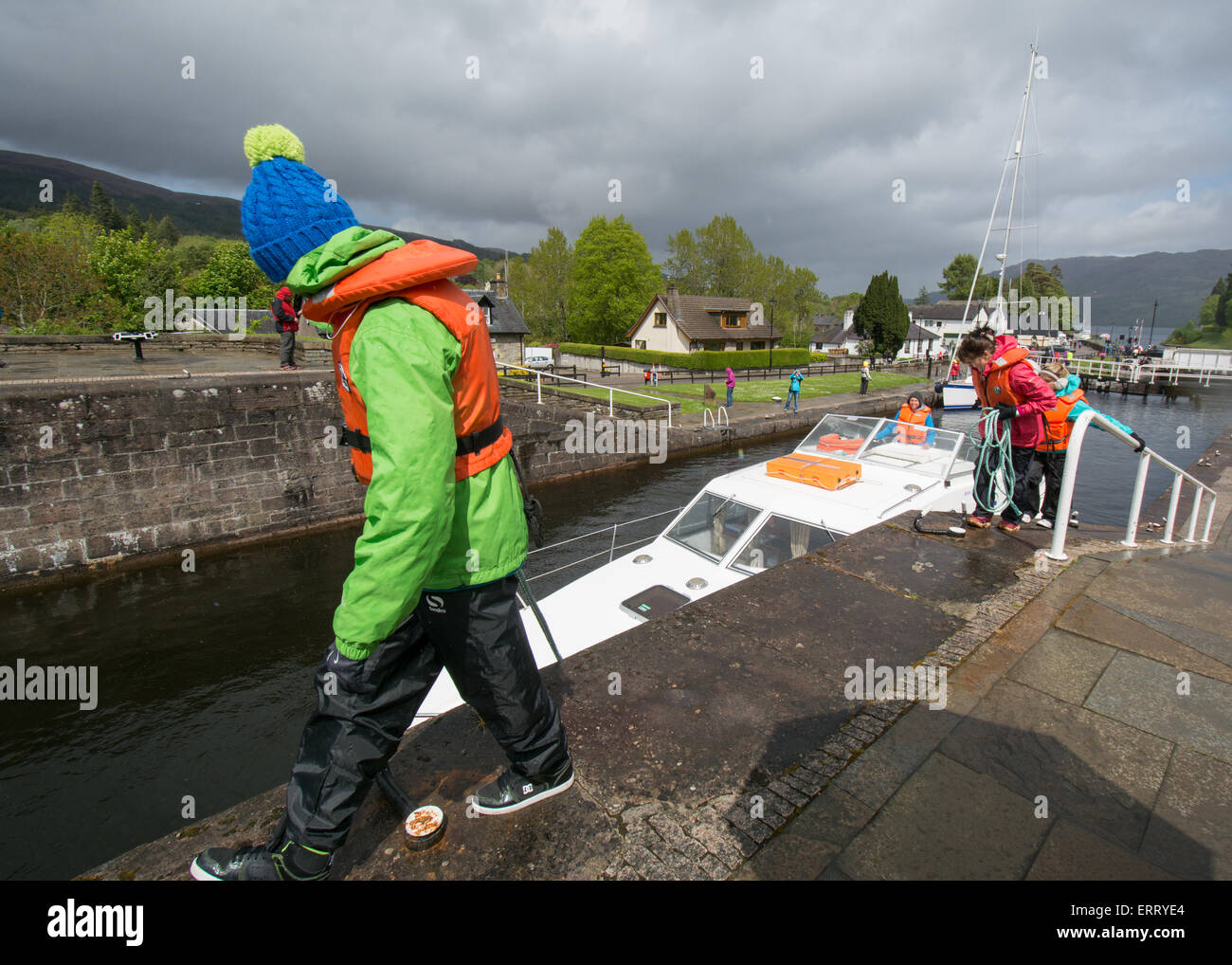 Women in brightly coloured waterproofs navigating a cruise boat through the locks on the Caledonian Canal at Fort Augustus Stock Photo