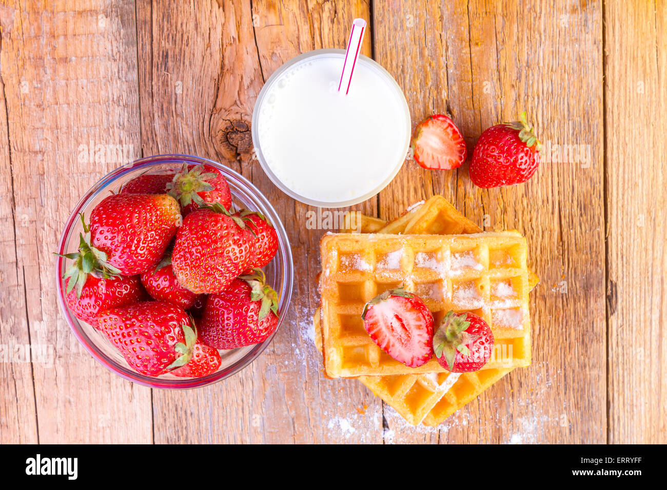 homemade waffles with strawberries and glass with milk on wooden background Stock Photo