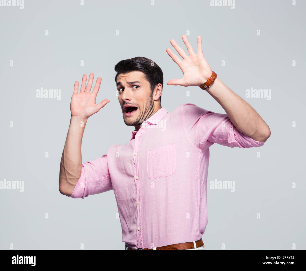 Scared and screaming businessman stop gesturing over gray background. Looking at camera Stock Photo