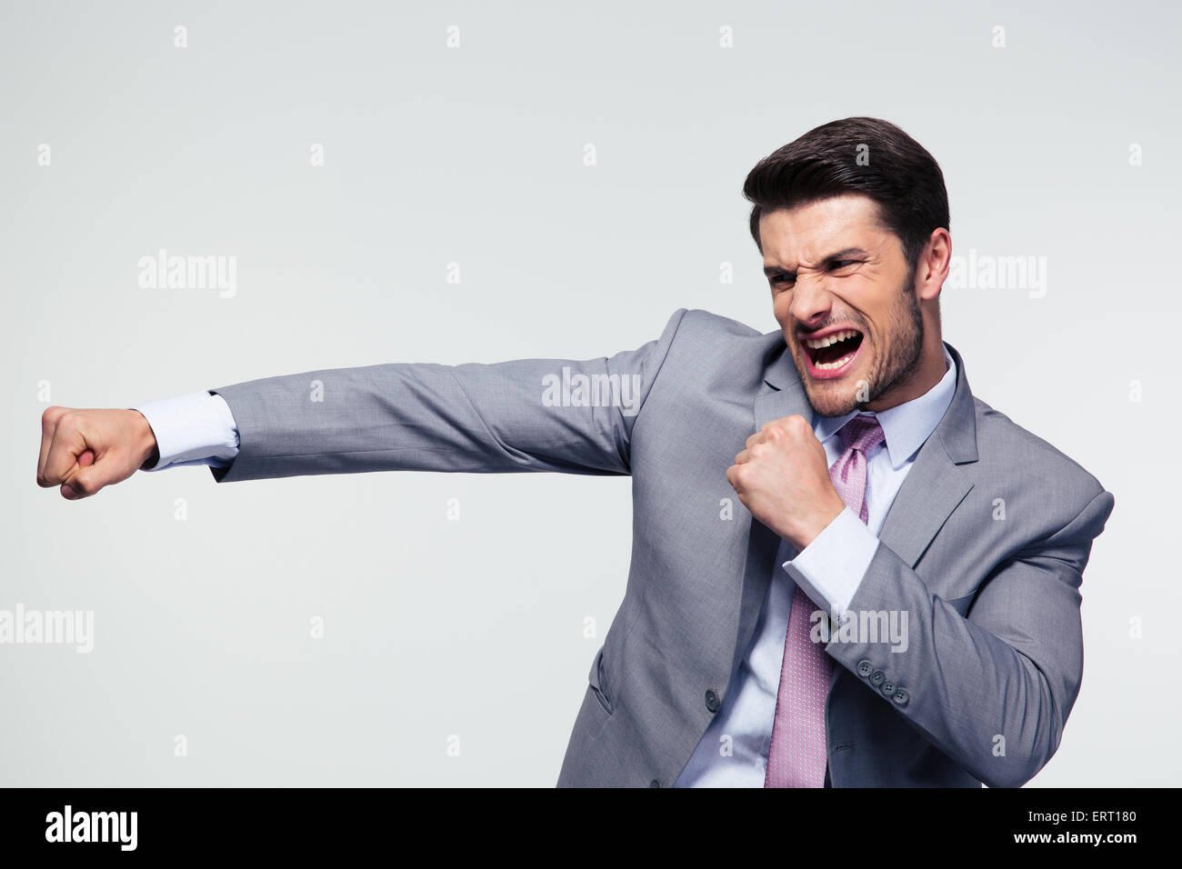 Angry businessman fighting and shouting over gray background Stock ...