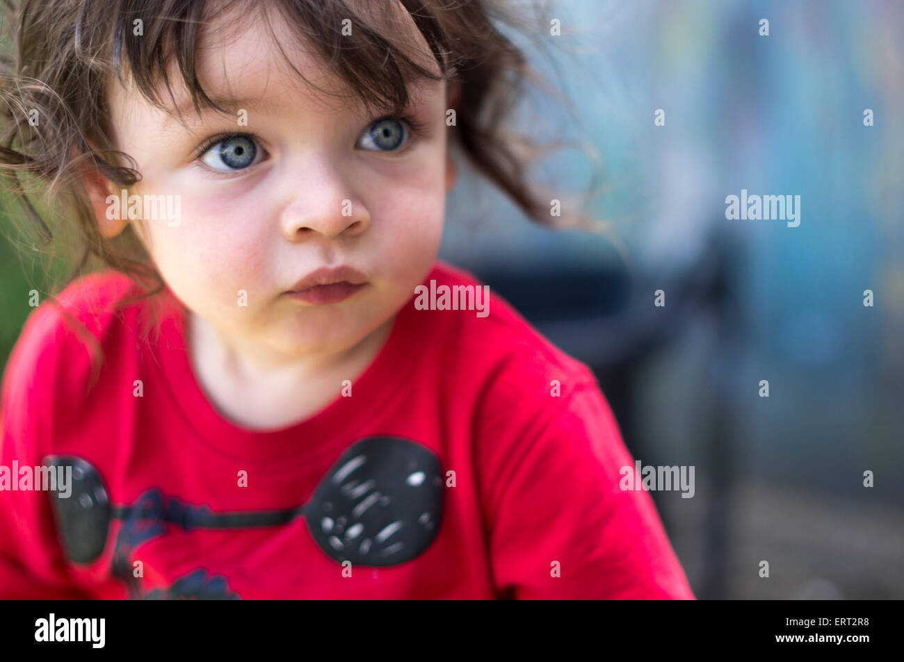 Wind swept blue eyed boy in red. Stock Photo