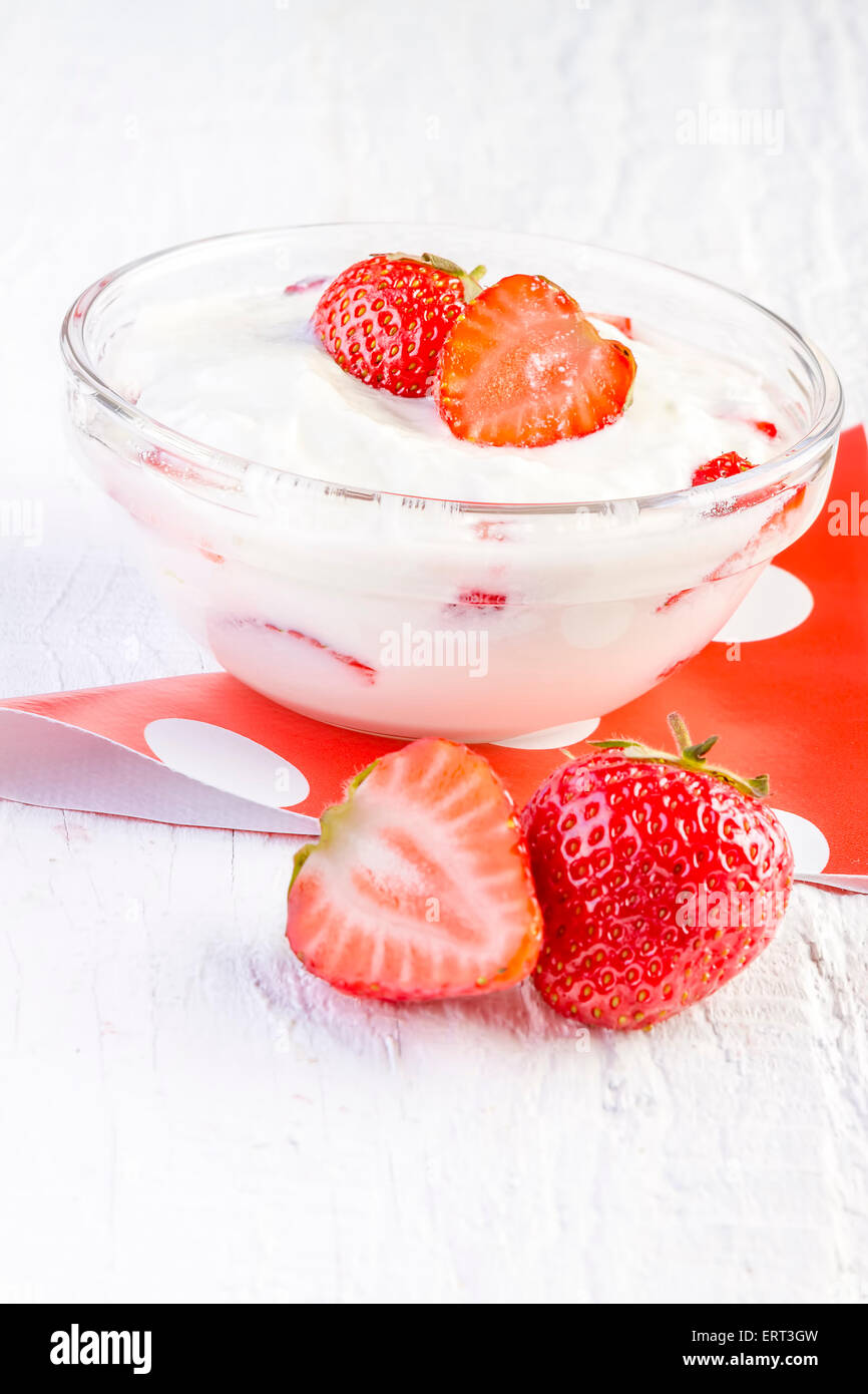strawberry and yogurt in a wooden bowl on white wooden background Stock Photo