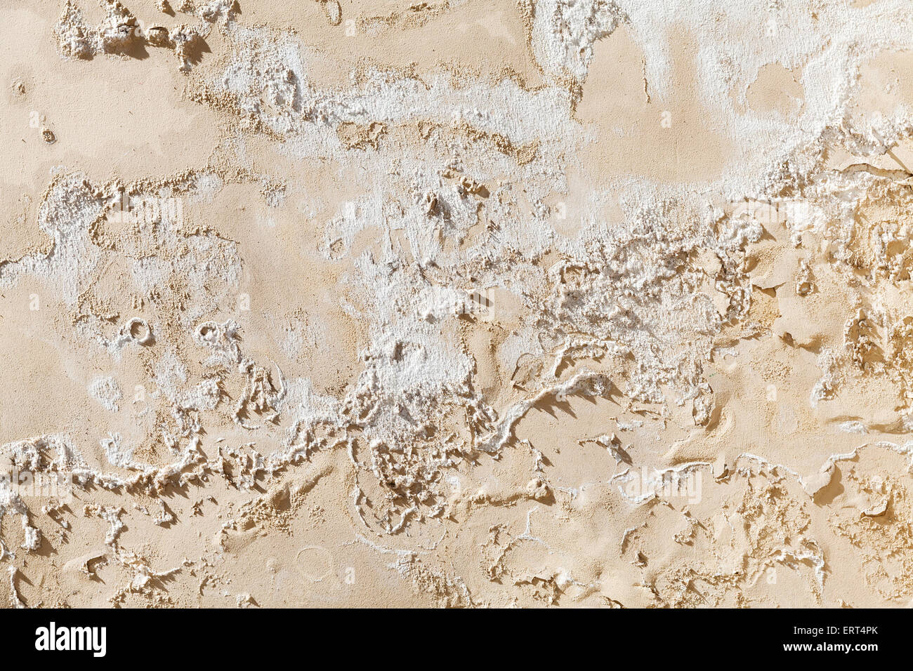 Old damaged yellow concrete wall with cracked paint relief, background texture Stock Photo