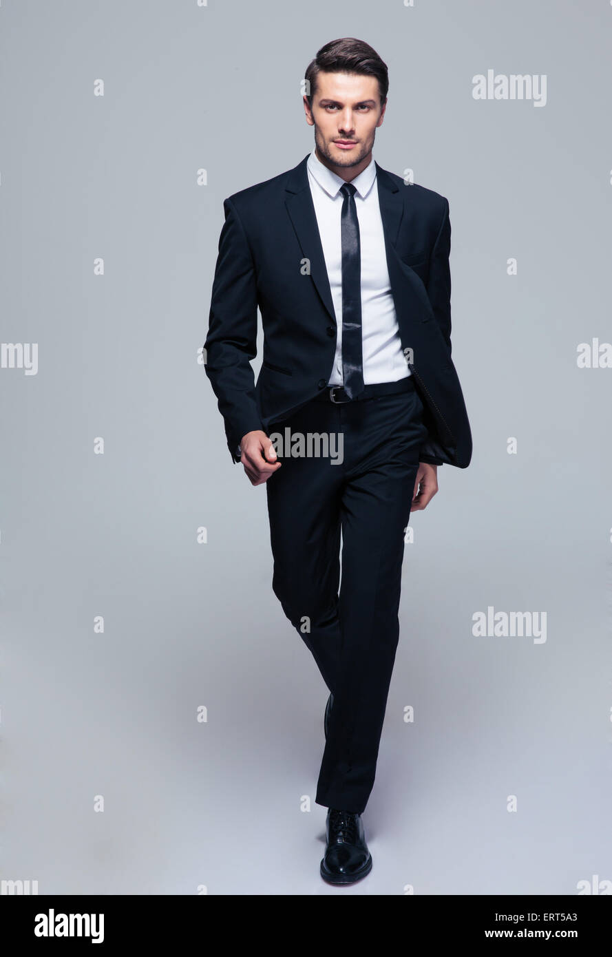 Full length portrait of a fashion male model over gray background. Looking at camera Stock Photo