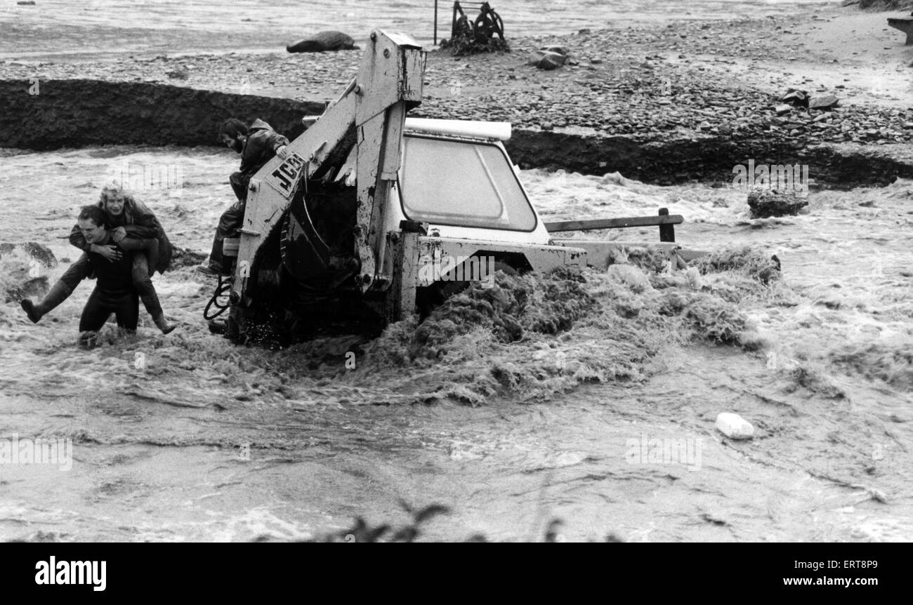 The driver of an excavator is rescued at Nolton Haven, Haverfordwest following the storms of 1987, the worst in almost 300 years.  20th October 1987. Stock Photo