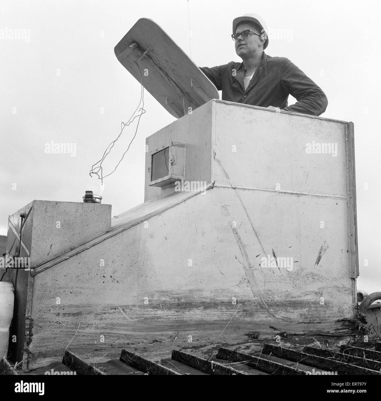 Armoured Tractor, ploughing fields littered with shells and bombs, 31st August 1969. Forestry Commission volunteers help reclaim 900 acres of a Royal Artillery range for forestry work, Trawsfynydd, Merioneth, North Wales. Ploughman John Jones, wearing steel helmet and drives an armoured tractor, one of 12 Forestry Commission volunteers. Stock Photo