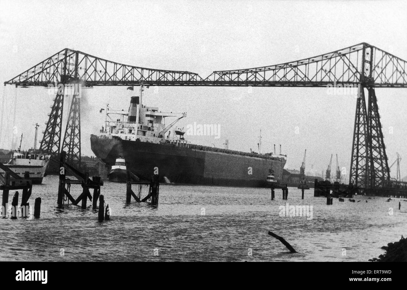 The 100,000 ton Dunstanburgh Castle inches her way down the Tees. Hundreds of sightseers lined the banks as the six tugs nosed the giant ship from the Swan Hunter fitting out basin at Haverton Hill and escorted her, stern first towards the Transporter Bridge. 2nd March 1970 Stock Photo