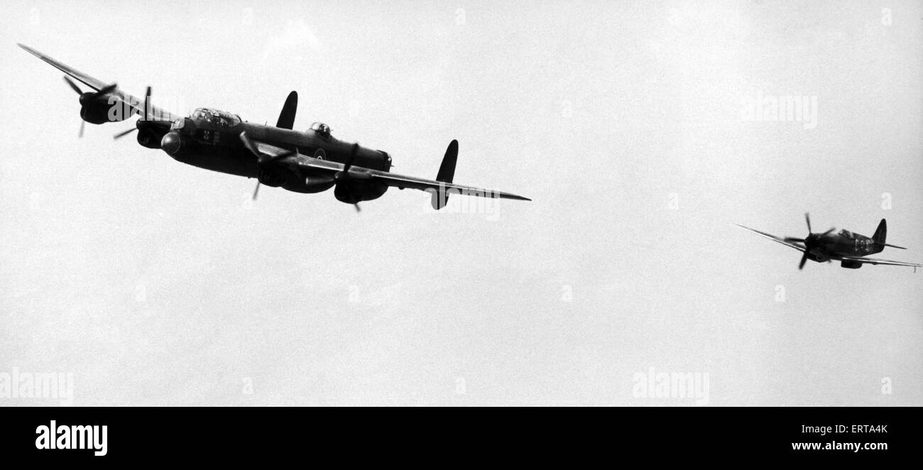 An Avro Lancaster bomber and Spitfire fighter plane of the Royal Air Force in flight during a display at Coventry Airport at Baginton. August 1976. Stock Photo