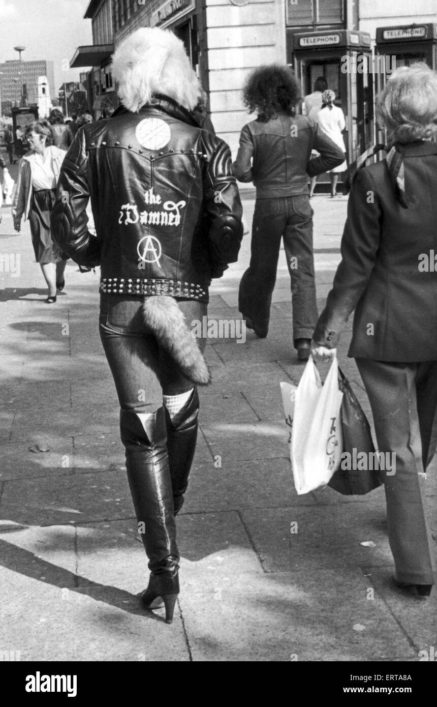 A young punk rocker walking down Colmore Road, Birmingham, with a fox tail hanging from their waist. 8th October 1980. Stock Photo