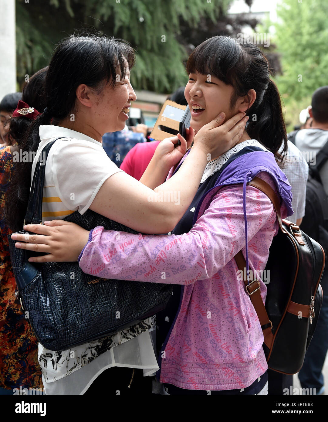 Zhengzhou, China's Henan Province. 8th June, 2015. A student hugs her mother after finishing the National College Entrance Exam (NCEE) at Zhengzhou Huimin Middle School in Zhengzhou, capital of central China's Henan Province, June 8, 2015. The 2015 National College Entrance Exam ended on Monday in most parts of China (in a few provinces the NCEE will last for one more day). A total of 9.42 million students sat for the exams this year. © Li Bo/Xinhua/Alamy Live News Stock Photo