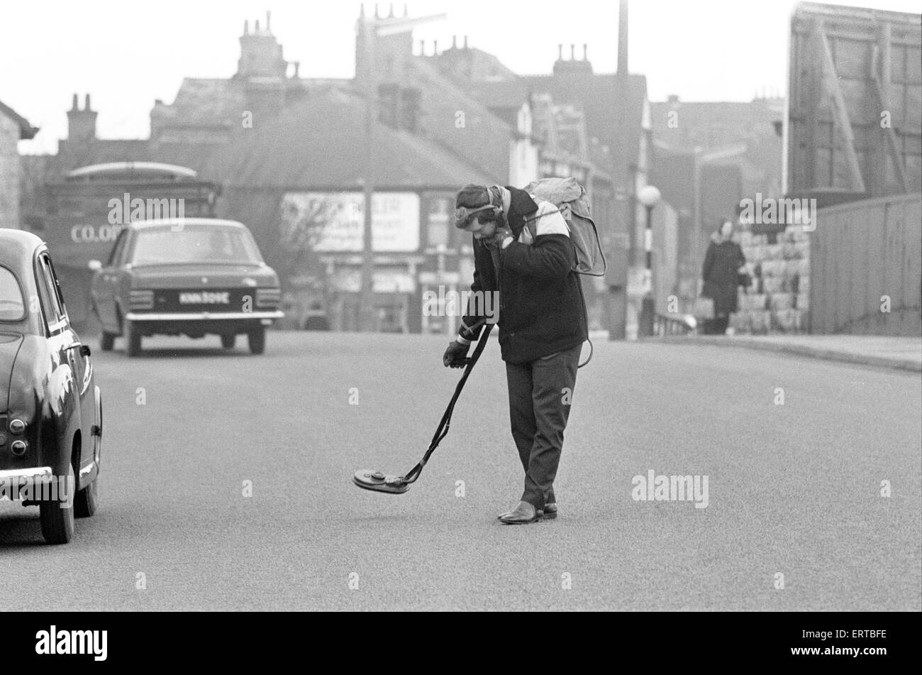 Roger Eyre, Assistant Engineer in training with the Urban District Council, Sutton in Ashfield, Notts, using defunct Mine Detector to locate manhole covers which have been covered by layers of asphalt as road were hurriedly re-surfaced, 26th January 1968. Stock Photo