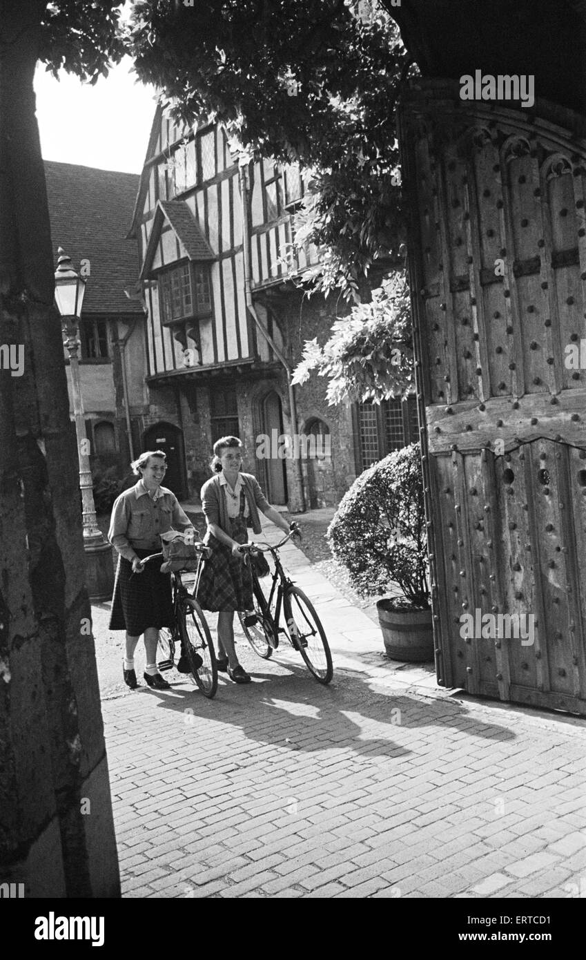 Two women pushing their bicycles through Cheyney's Court in Winchester, Circa 1945. Stock Photo