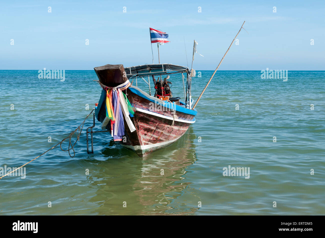 Bow view of a long tail Thai fishing boat moored in the shallows on a beach on Koh Samui island Thailand Stock Photo