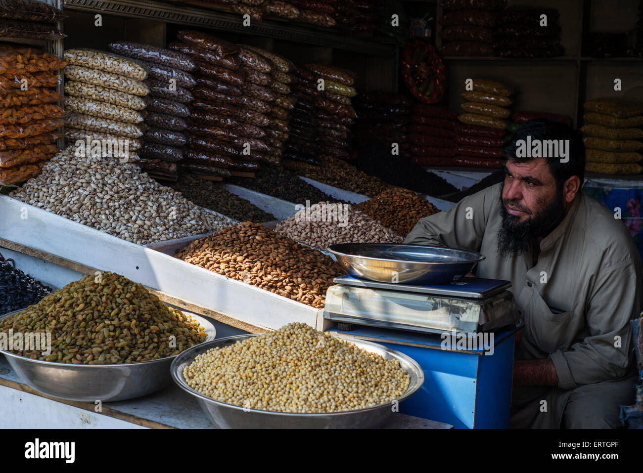 Afghan man sells nuts and seeds in street market in Third Macrorayan, neighborhood built-up by Soviet multistorey apartment houses during Soviet-Afghan military cooperation from 1970s to 1989, Kabul, Afghanistan Stock Photo