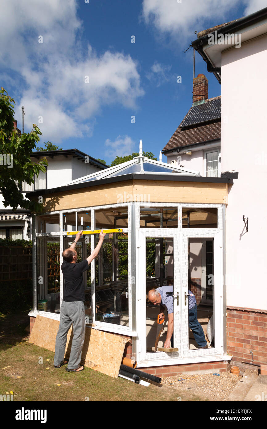 Builders at work building a conservatory as part of a house extension, UK Stock Photo
