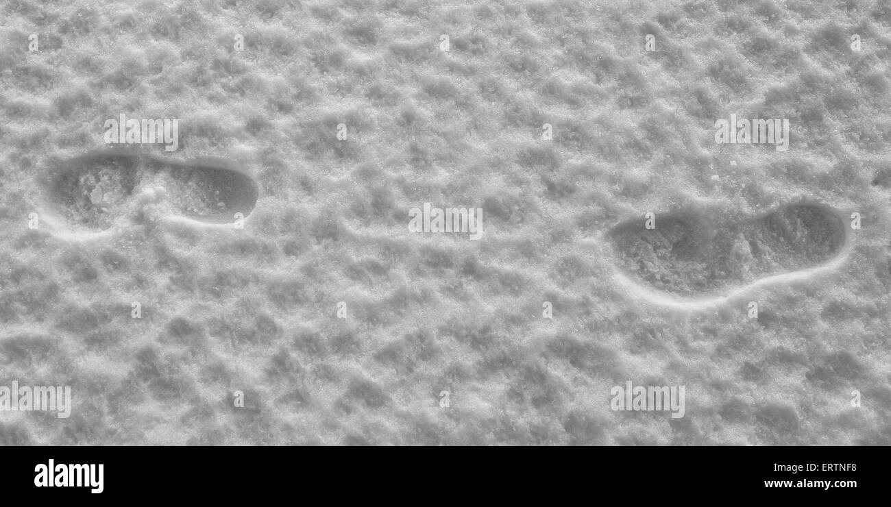A couple of human footsteps over frozen snow Stock Photo