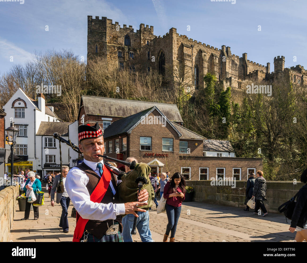 Durham - A piper plays bagpipes on Framwellgate Bridge over the River Wear with Durham Castle, Durham, England, UK Stock Photo