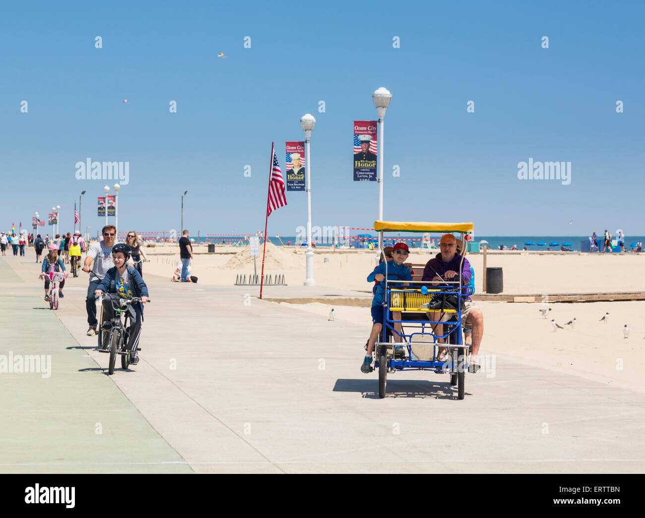 Tourists on bicycles on the  boardwalk of Ocean City, Maryland, USA in summer Stock Photo