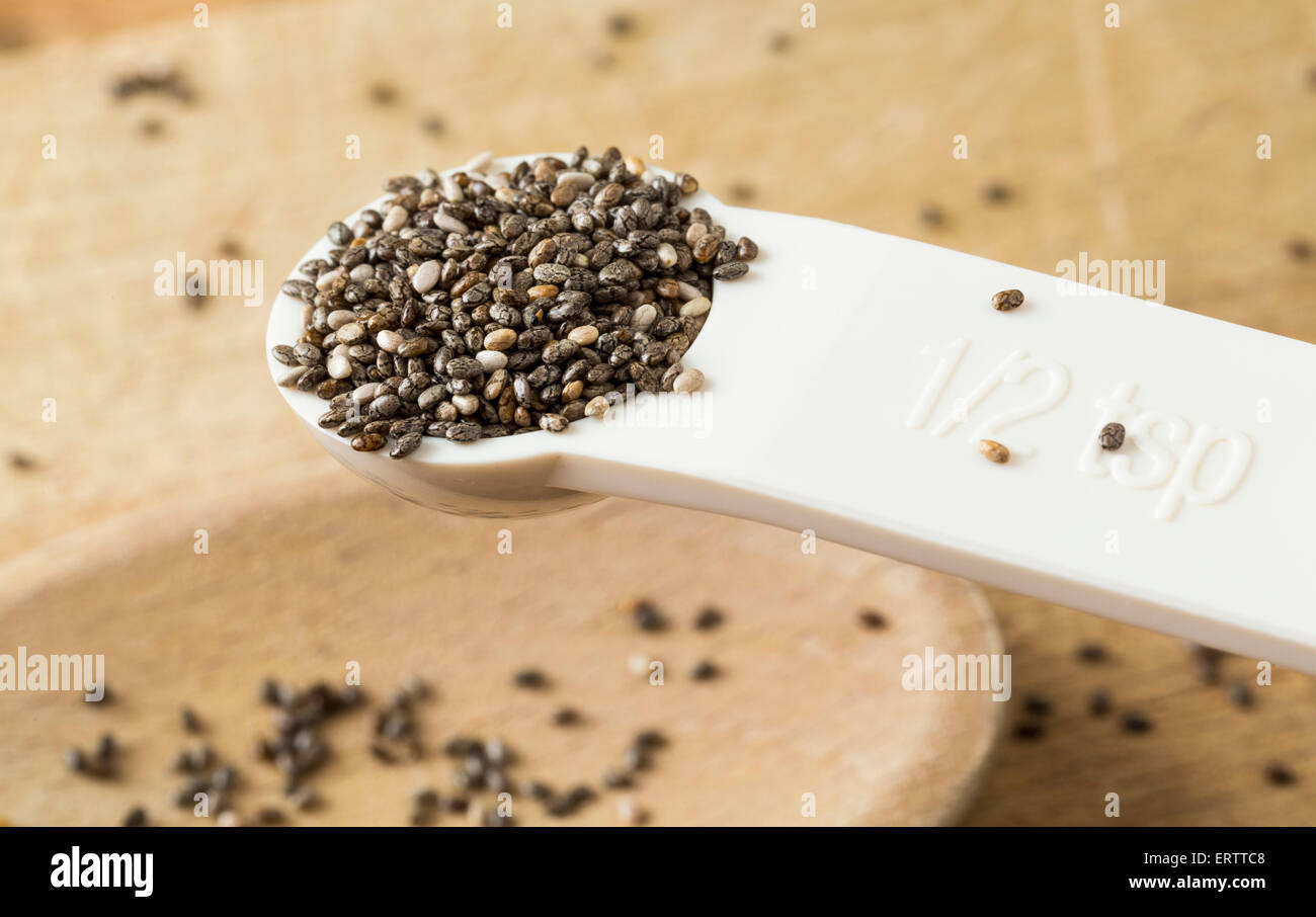 Superfood called black chia seeds in measuring spoon Stock Photo