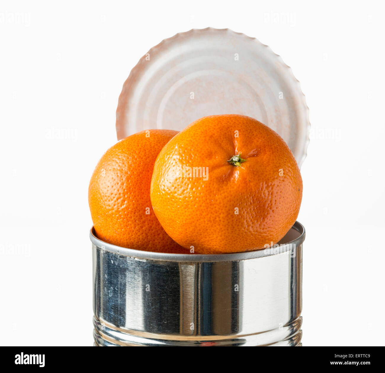Oranges / satsumas fruit heaped inside opened tin can - fresh food coming in cans concept Stock Photo