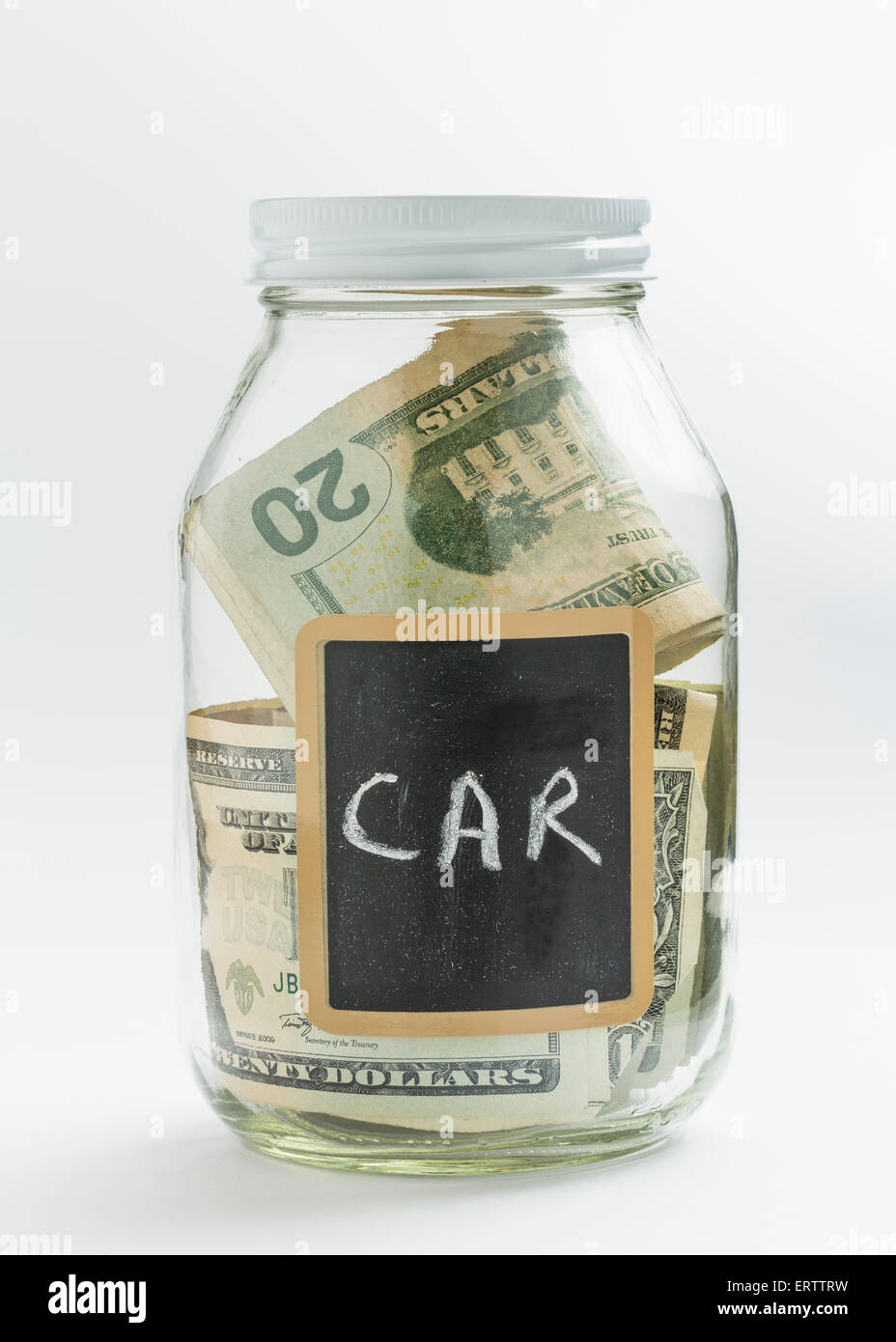 Glass jar used for saving US dollar bills to buy a car or for car expenses Stock Photo