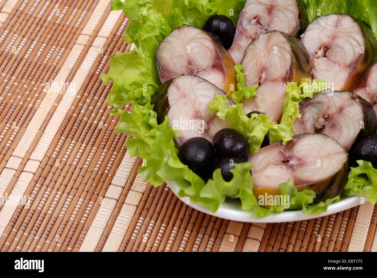 Composition from a smoked mackerel on a plate with vegetables Stock Photo