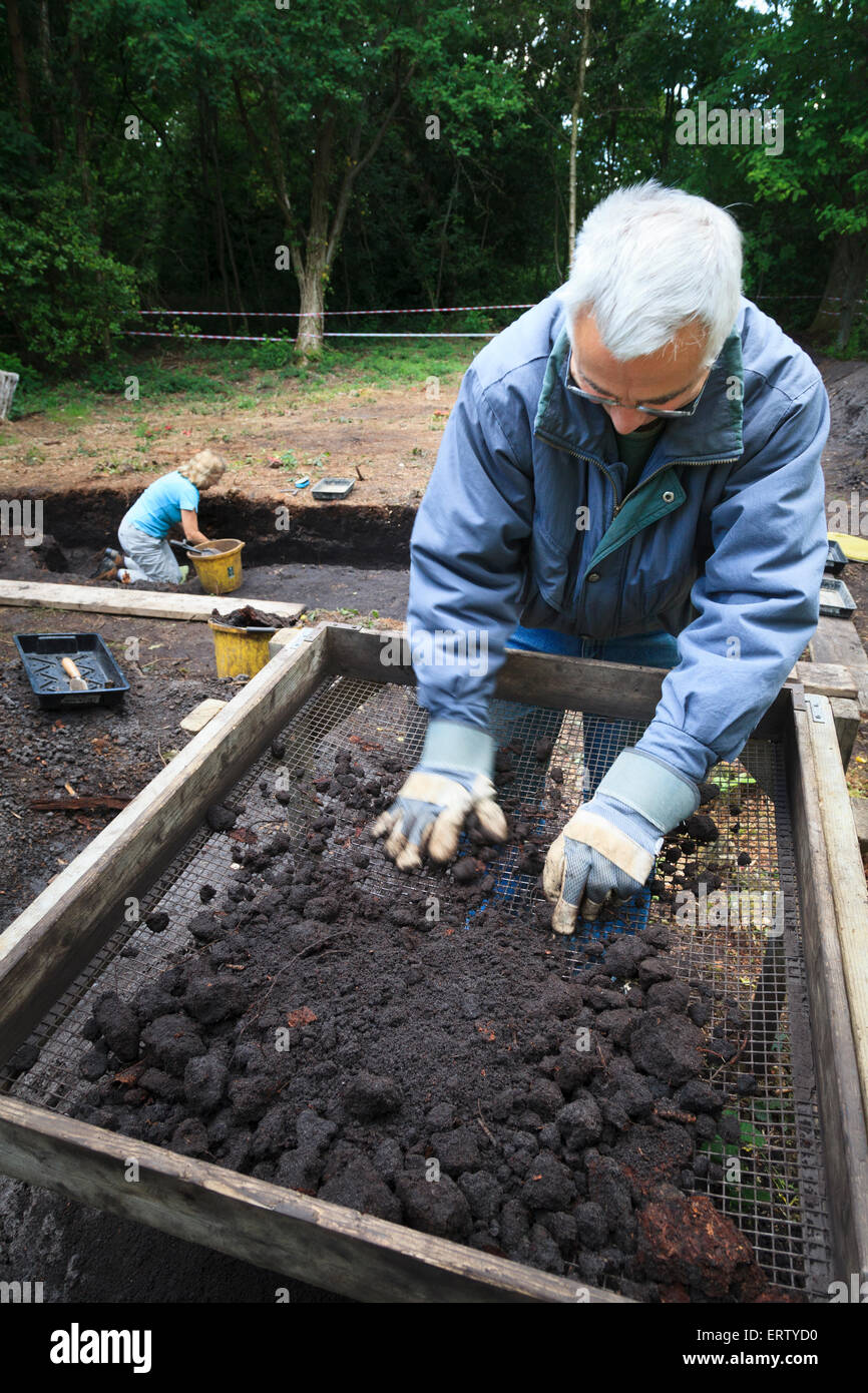 Archaeologists dry sieving in a shaker frame on a dig Stock Photo