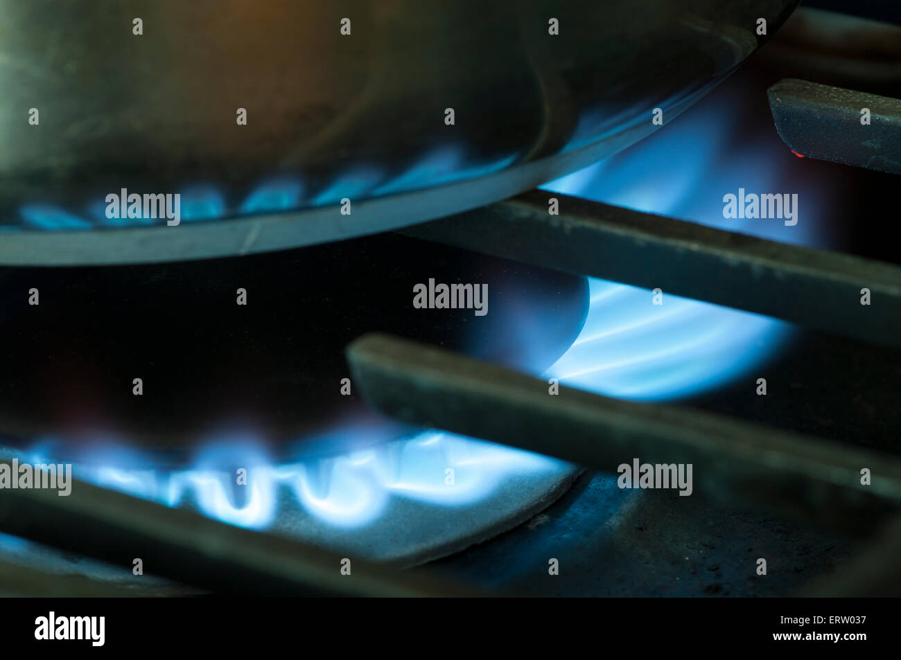 Natural gas  for heating and cooking; image is a close  up of a bright blue flame of gas used to heat or cook on a range top in a residential kitchen Stock Photo