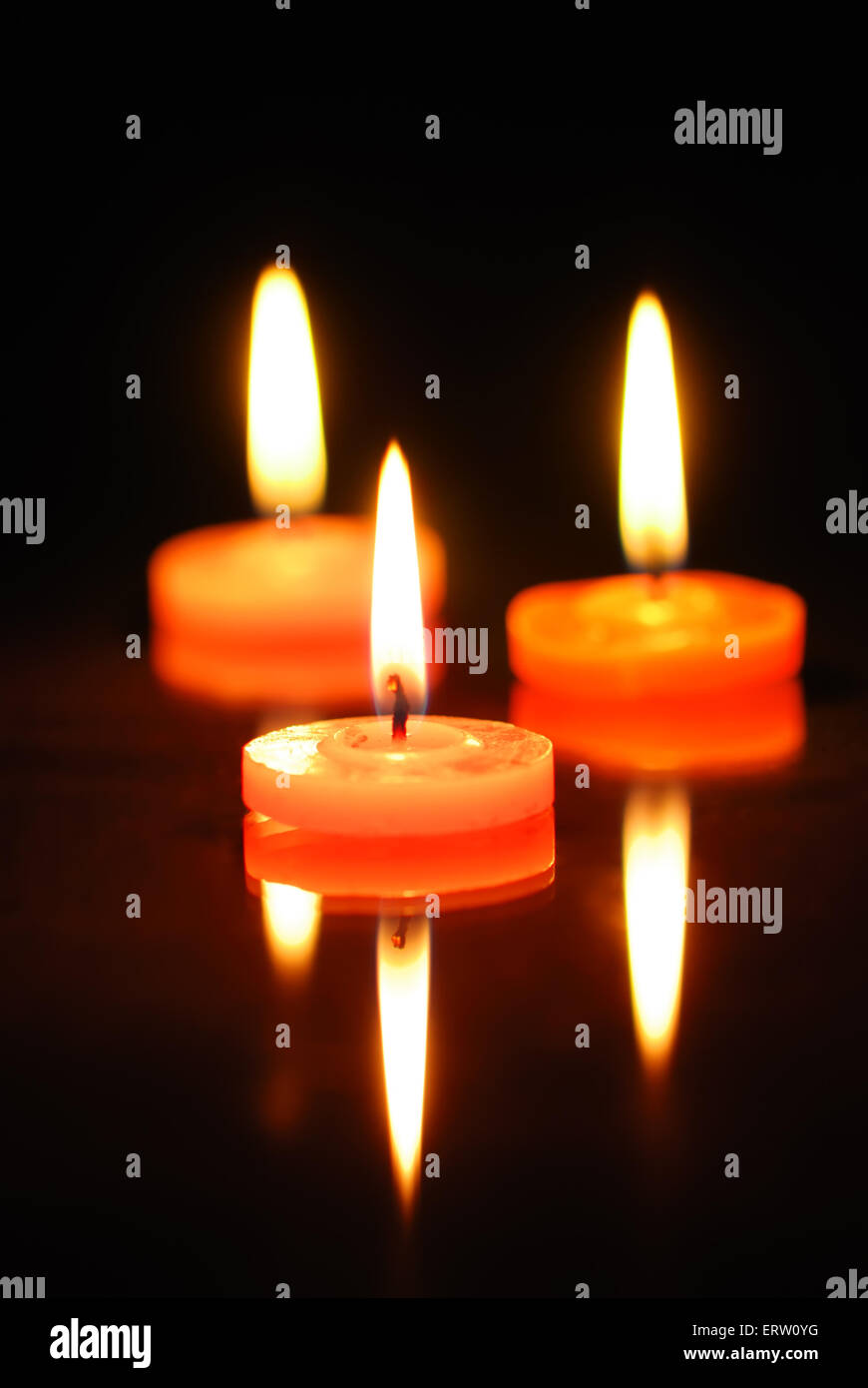 Three burning candles on black background Stock Photo - Alamy