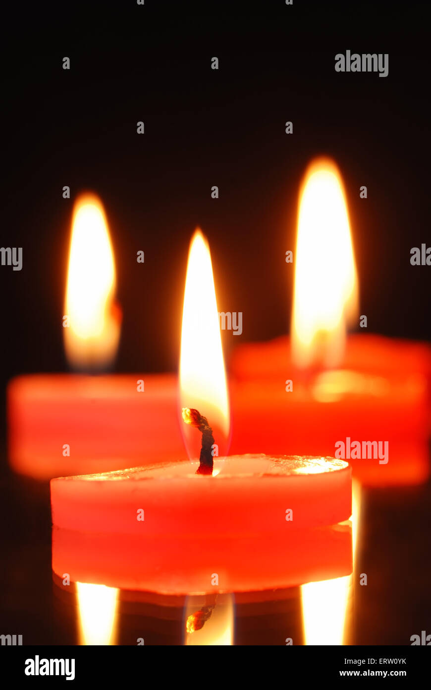 Three burning candles on black background Stock Photo - Alamy