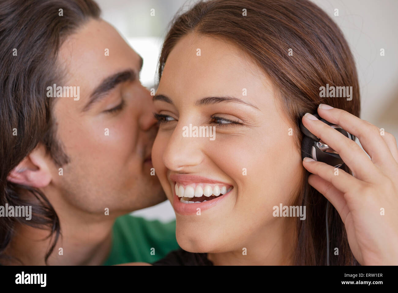 Man whispering woman's ear hires stock