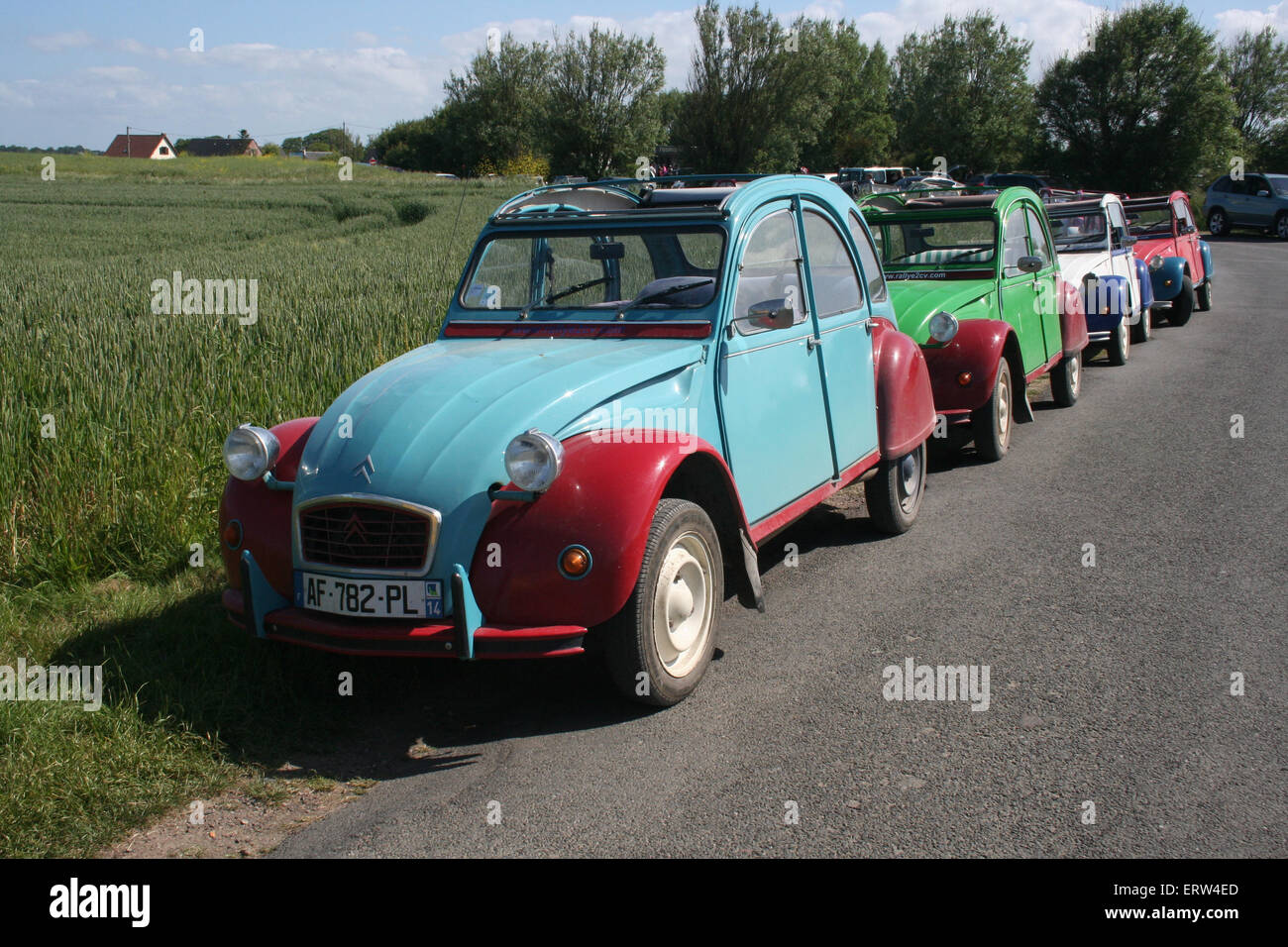 Line of 2CV's on a tour of the D-Day sights. Normandy France. Stock Photo