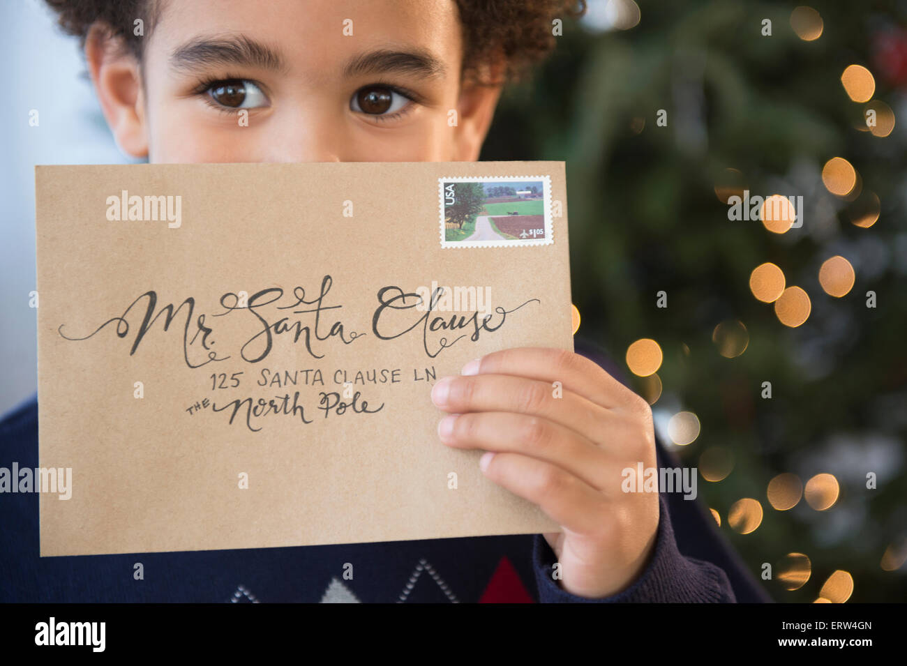 Mixed race boy holding letter to Santa for Christmas Stock Photo