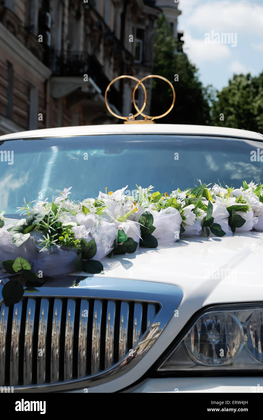 White wedding limousine decorated with flowers and rings Stock Photo