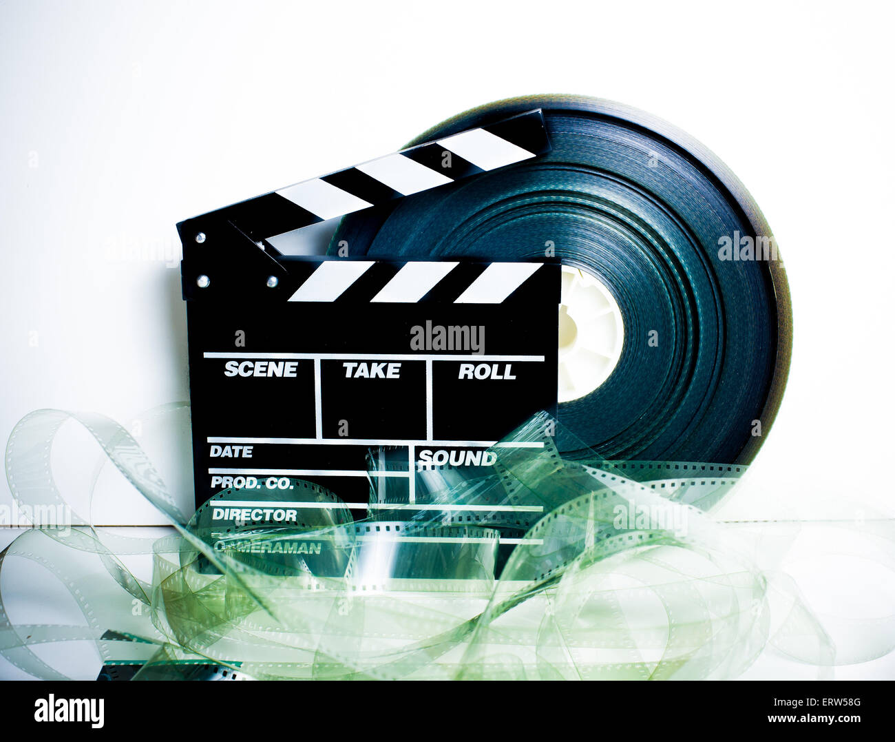 Movie clapper board and 35 mm film reel on white background