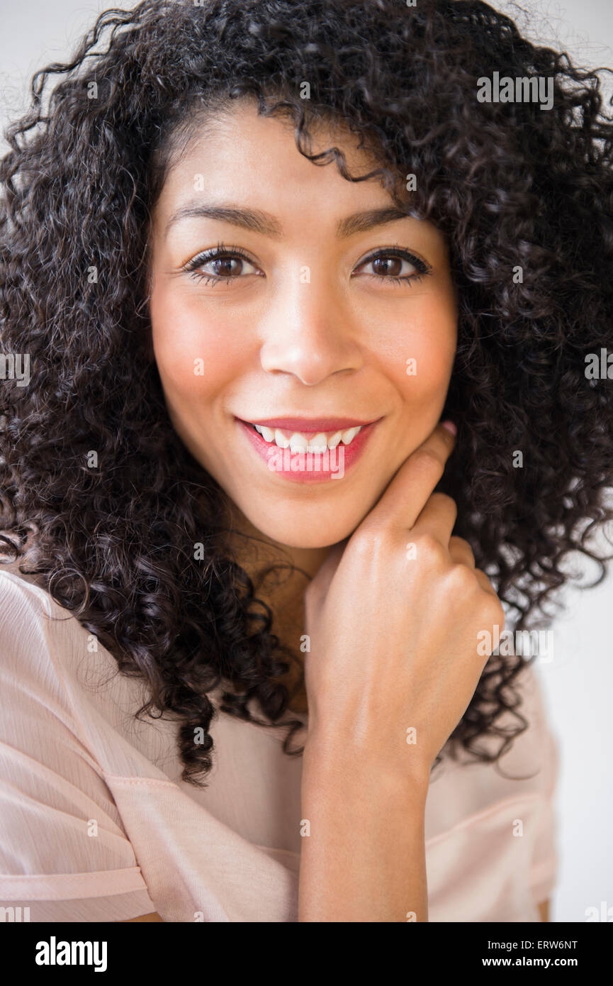 Mixed race woman with curly hair smiling Stock Photo