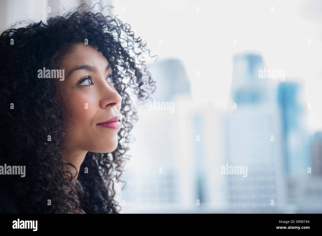 Mixed race businesswoman looking out window Stock Photo