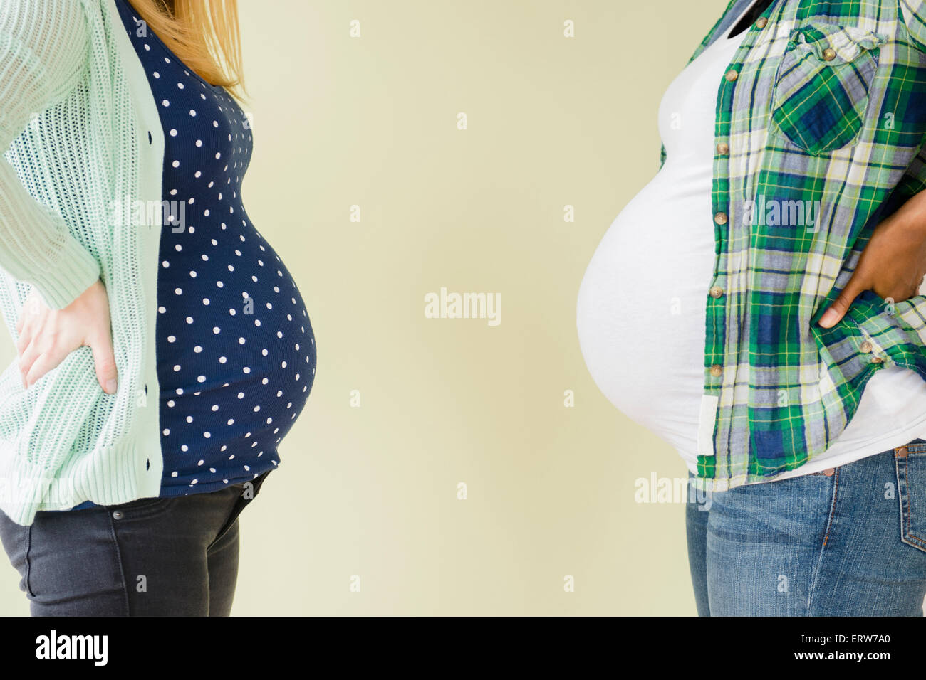 Pregnant women displaying profile of midsections Stock Photo