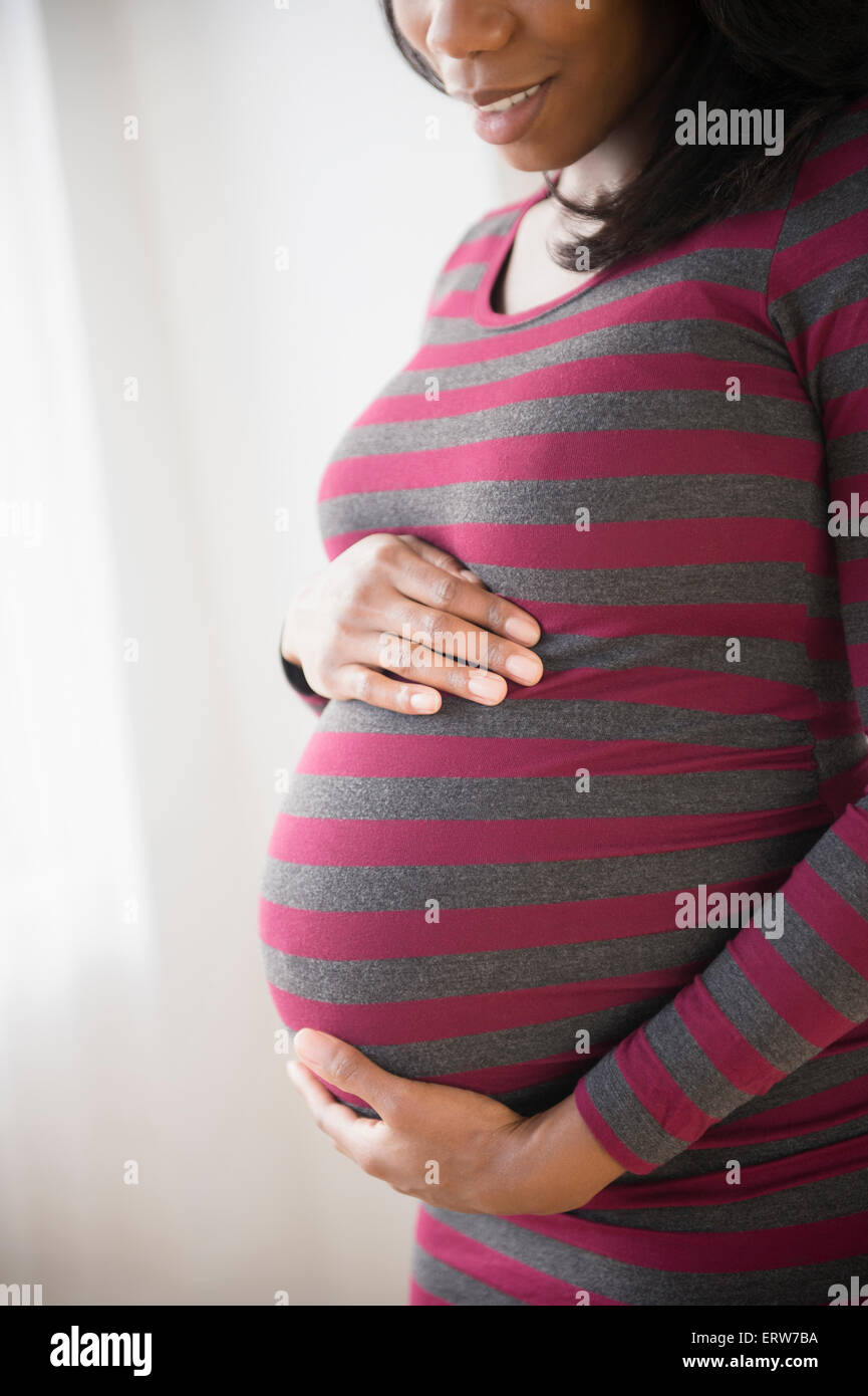 Black pregnant woman admiring her stomach Stock Photo