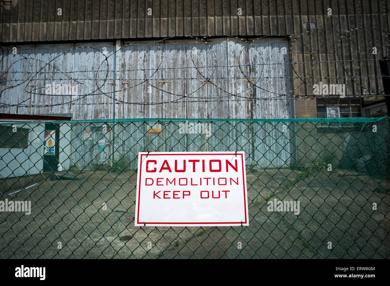 Caution demolition keep out sign on a fence of a construction site Stock Photo