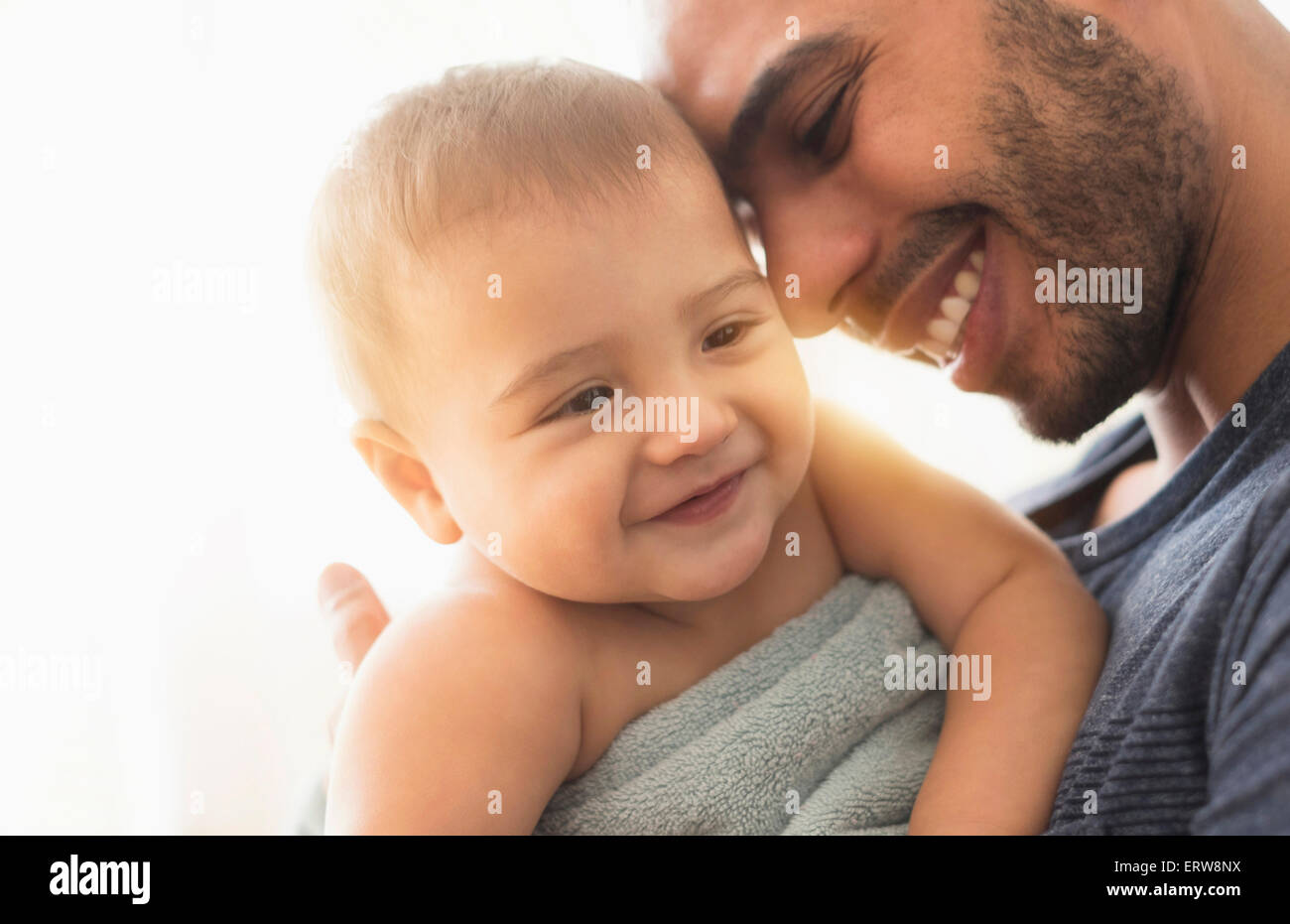 Father drying baby son with towel after bath Stock Photo