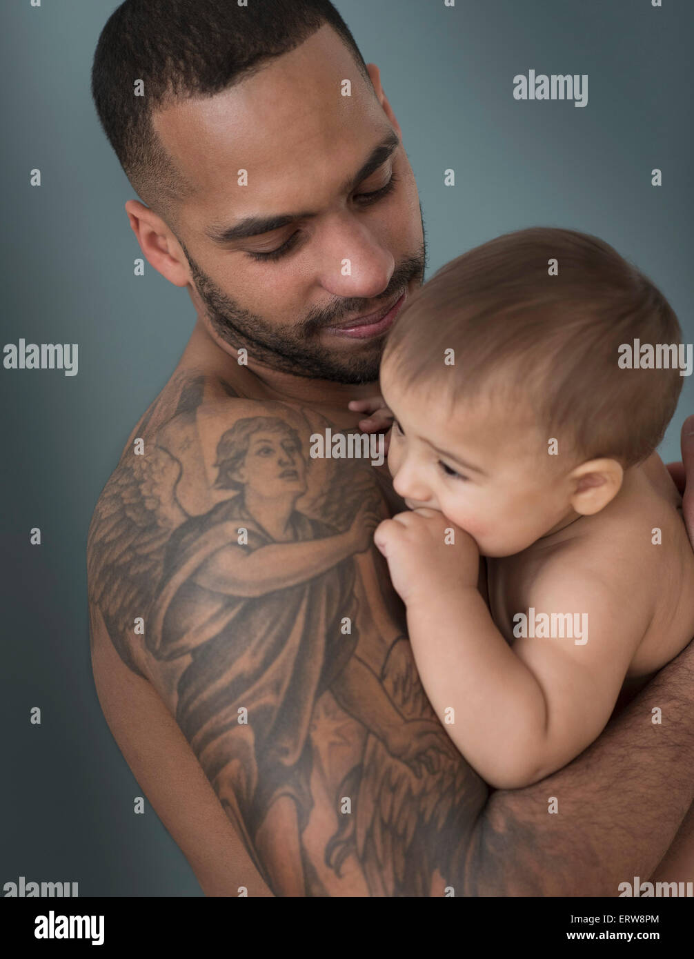 Father with tattoos holding baby son Stock Photo - Alamy