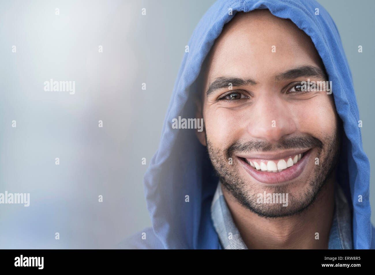 Smiling Hispanic man wearing hoodie Stock Photo