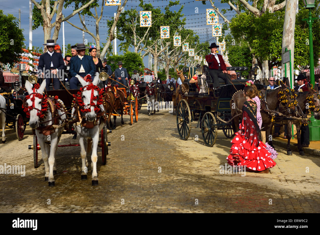 Horse and mule drawn carriages on cobblestone street of Seville April Fair Stock Photo