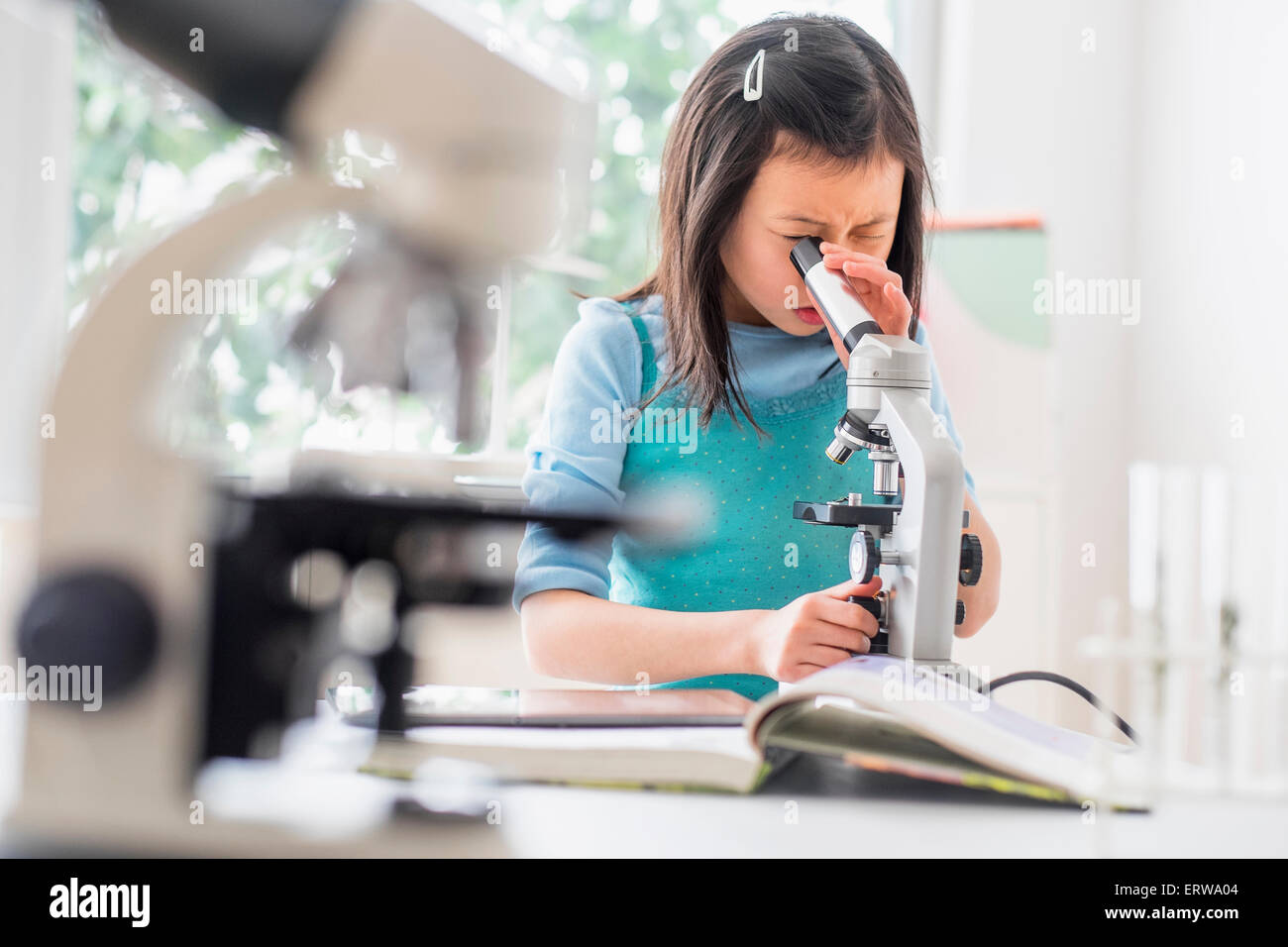Chinese student using microscope in science lab Stock Photo