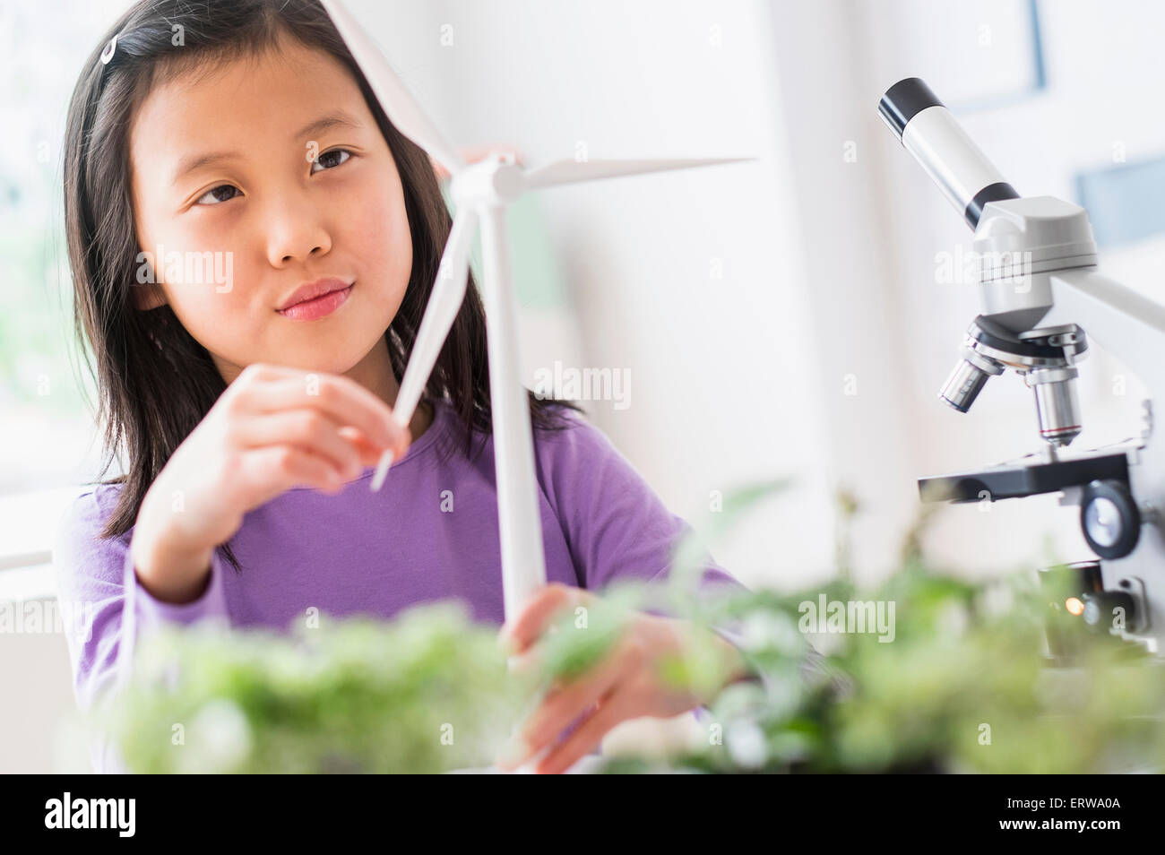 Chinese student examining model wind turbine in science lab Stock Photo