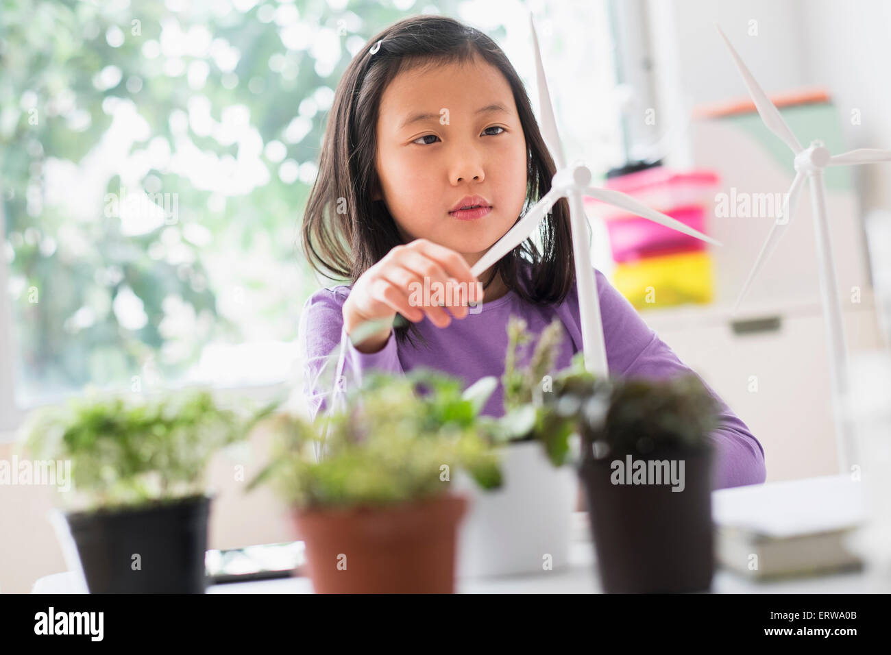 Chinese student examining model wind turbine in science lab Stock Photo